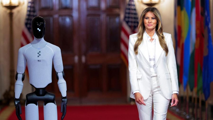 U.S. first lady Melania Trump walks next to a humanoid robot as she hosts a roundtable event on the second day of the inaugural Fostering the Future Together Global Coalition Summit, at the White House in Washington, D.C., U.S., March 25, 2026. REUTERS/Kylie Cooper      TPX IMAGES OF THE DAY