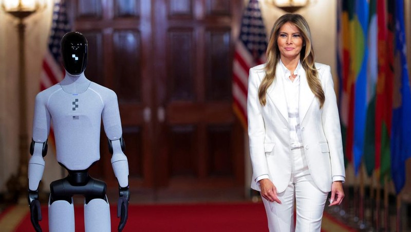 U.S. first lady Melania Trump walks next to a humanoid robot as she hosts a roundtable event on the second day of the inaugural Fostering the Future Together Global Coalition Summit, at the White House in Washington, D.C., U.S., March 25, 2026. REUTERS/Kylie Cooper      TPX IMAGES OF THE DAY