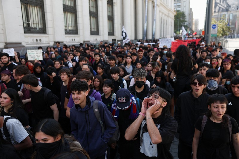 A demonstrator throws an object as a water cannon is used during a protest against the Chilean government's budget cuts to education, in Santiago, Chile, March 26, 2026. REUTERS/Pablo Sanhueza