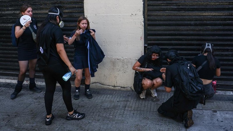 A demonstrator throws an object as a water cannon is used during a protest against the Chilean government's budget cuts to education, in Santiago, Chile, March 26, 2026. REUTERS/Pablo Sanhueza
