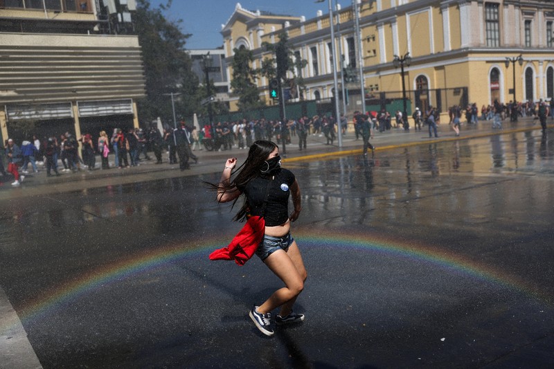 A demonstrator throws an object as a water cannon is used during a protest against the Chilean government's budget cuts to education, in Santiago, Chile, March 26, 2026. REUTERS/Pablo Sanhueza