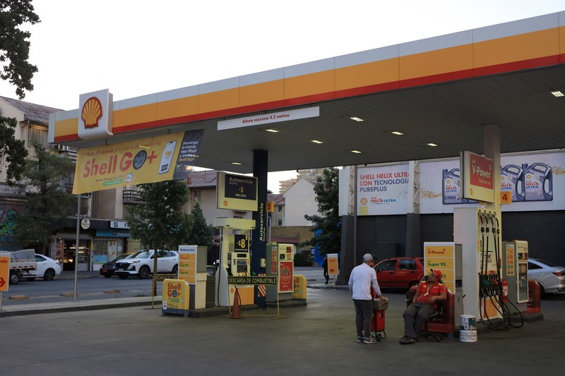Workers at a gas station without fuel after Chile&rsquo;s government activated a clause in its fuel‑stabilization mechanism to quickly bring domestic prices in line with surging international rates linked to conflict in the Middle East, in Santiago, Chile, March 26, 2026. REUTERS/Diego Reyes