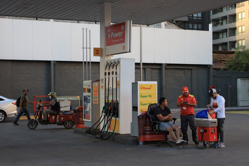 Workers at a gas station without fuel after Chile&rsquo;s government activated a clause in its fuel‑stabilization mechanism to quickly bring domestic prices in line with surging international rates linked to conflict in the Middle East, in Santiago, Chile, March 26, 2026. REUTERS/Diego Reyes