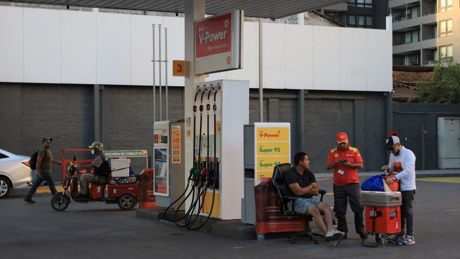Workers at a gas station without fuel after Chile&rsquo;s government activated a clause in its fuel‑stabilization mechanism to quickly bring domestic prices in line with surging international rates linked to conflict in the Middle East, in Santiago, Chile, March 26, 2026. REUTERS/Diego Reyes