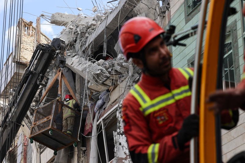 Petugas tanggap darurat mengevakuasi korban dari bawah reruntuhan di lokasi bangunan tempat tinggal yang rusak akibat serangan udara, di tengah konflik AS-Israel dengan Iran, di Teheran, Iran, 27 Maret 2026. (Majid Asgaripour/WANA (West Asia News Agency) via REUTERS)