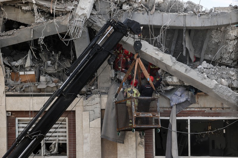 Petugas tanggap darurat mengevakuasi korban dari bawah reruntuhan di lokasi bangunan tempat tinggal yang rusak akibat serangan udara, di tengah konflik AS-Israel dengan Iran, di Teheran, Iran, 27 Maret 2026. (Majid Asgaripour/WANA (West Asia News Agency) via REUTERS)