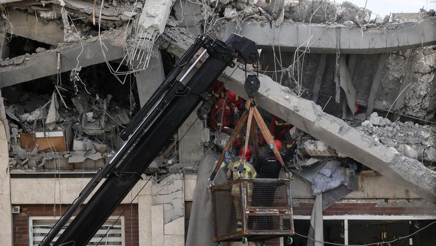 Petugas tanggap darurat mengevakuasi korban dari bawah reruntuhan di lokasi bangunan tempat tinggal yang rusak akibat serangan udara, di tengah konflik AS-Israel dengan Iran, di Teheran, Iran, 27 Maret 2026. (Majid Asgaripour/WANA (West Asia News Agency) via REUTERS)