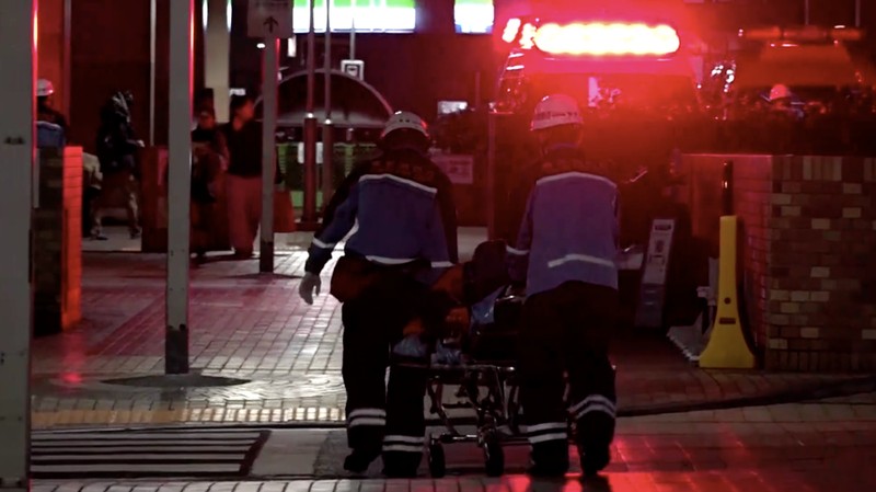 Petugas penyelamat berjalan di depan kompleks komersial tempat seorang karyawan wanita di toko merchandise Pokemon ditikam hingga tewas di distrik Ikebukuro di Tokyo, Jepang, 26 Maret 2026, dalam foto yang diambil oleh Kyodo. (Mandatory credit Kyodo/via REUTERS)