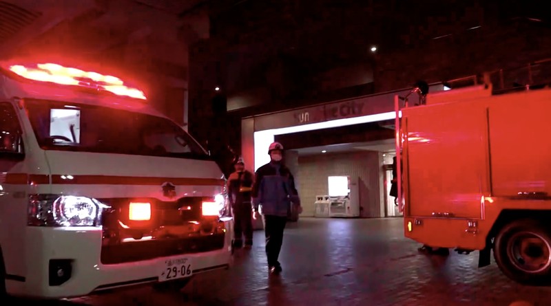 Petugas penyelamat berjalan di depan kompleks komersial tempat seorang karyawan wanita di toko merchandise Pokemon ditikam hingga tewas di distrik Ikebukuro di Tokyo, Jepang, 26 Maret 2026, dalam foto yang diambil oleh Kyodo. (Mandatory credit Kyodo/via REUTERS)