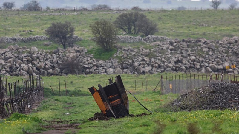 Seorang gadis berpose untuk foto di samping sisa-sisa rudal yang tertancap di tanah yang ditemukan di desa Kifl Haris, dekat Nablus di Tepi Barat yang diduduki Israel, 24 Maret 2026. (REUTERS/Mohammed Torokman/File Photo)