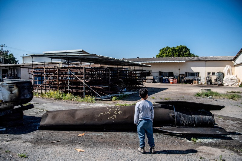 Seorang gadis berpose untuk foto di samping sisa-sisa rudal yang tertancap di tanah yang ditemukan di desa Kifl Haris, dekat Nablus di Tepi Barat yang diduduki Israel, 24 Maret 2026. (REUTERS/Mohammed Torokman/File Photo)