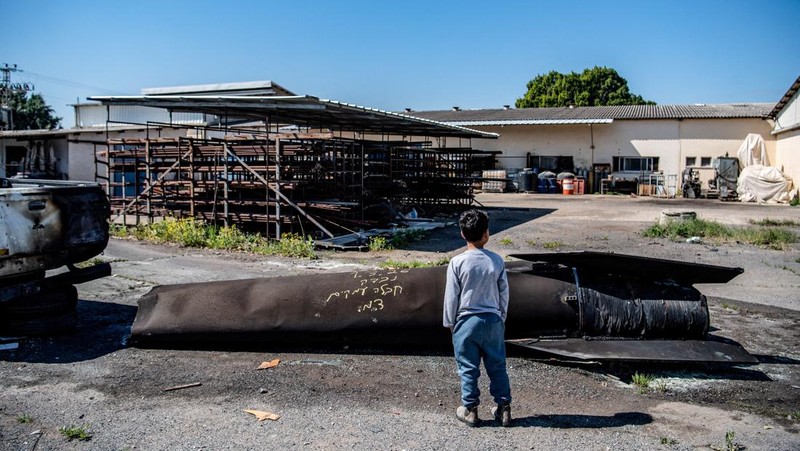 Seorang gadis berpose untuk foto di samping sisa-sisa rudal yang tertancap di tanah yang ditemukan di desa Kifl Haris, dekat Nablus di Tepi Barat yang diduduki Israel, 24 Maret 2026. (REUTERS/Mohammed Torokman/File Photo)