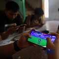 Sejumlah anak memainkan ponsel mereka sesuai pulang sekolah di Jakarta, Senin (30/3/2026). Pemerintah resmi melarang anak di bawah usia 16 tahun menggunakan media sosial mulai 28 Maret 2026 berdasarkan Peraturan Menteri Komunikasi dan Digital Nomor 9