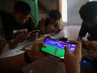 Sejumlah anak memainkan ponsel mereka sesuai pulang sekolah di Jakarta, Senin (30/3/2026). Pemerintah resmi melarang anak di bawah usia 16 tahun menggunakan media sosial mulai 28 Maret 2026 berdasarkan Peraturan Menteri Komunikasi dan Digital Nomor 9