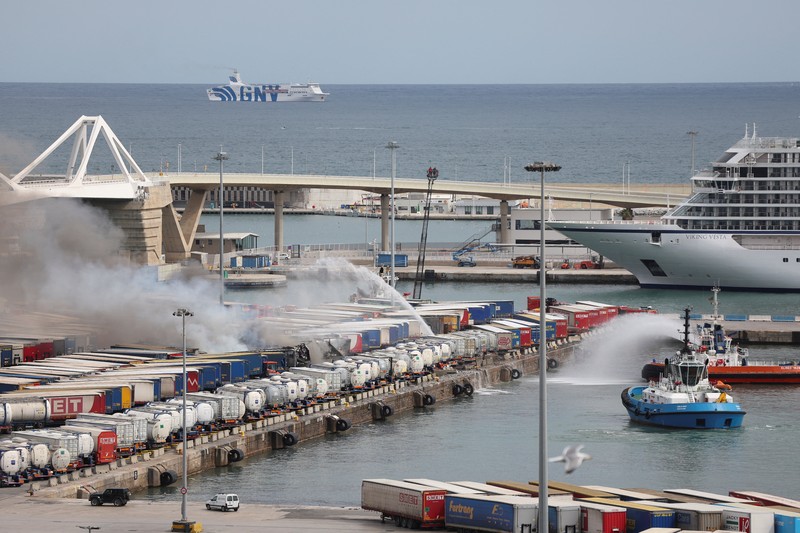 Petugas pemadam kebakaran berupaya memadamkan api di pelabuhan Barcelona setelah sebuah kendaraan dan beberapa kontainer pelabuhan terbakar, di Barcelona, ​​Spanyol, 29 Maret 2026. REUTERS/Bruna Casas