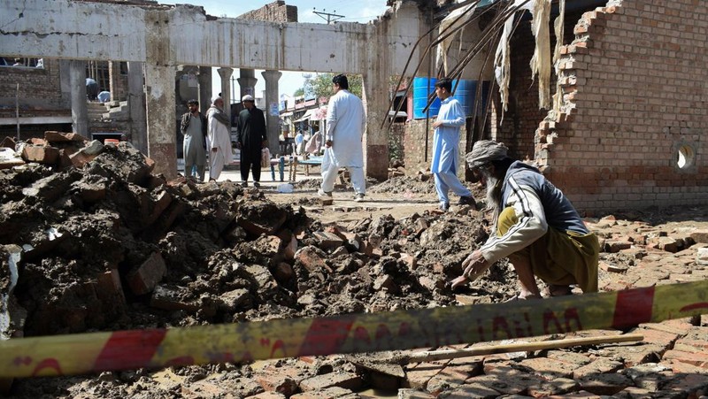 Seseorang berjalan melewati atap sebuah rumah yang runtuh setelah hujan lebat di Abbottabad, provinsi Khyber Pakhtunkhwa di Pakistan, 30 Maret 2026. (REUTERS/Sultan Dogar)