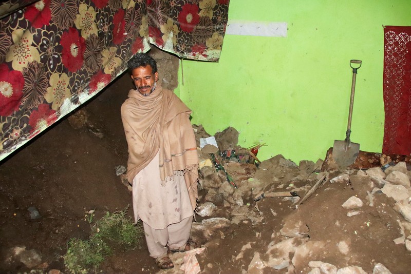 Seseorang berjalan melewati atap sebuah rumah yang runtuh setelah hujan lebat di Abbottabad, provinsi Khyber Pakhtunkhwa di Pakistan, 30 Maret 2026. (REUTERS/Sultan Dogar)