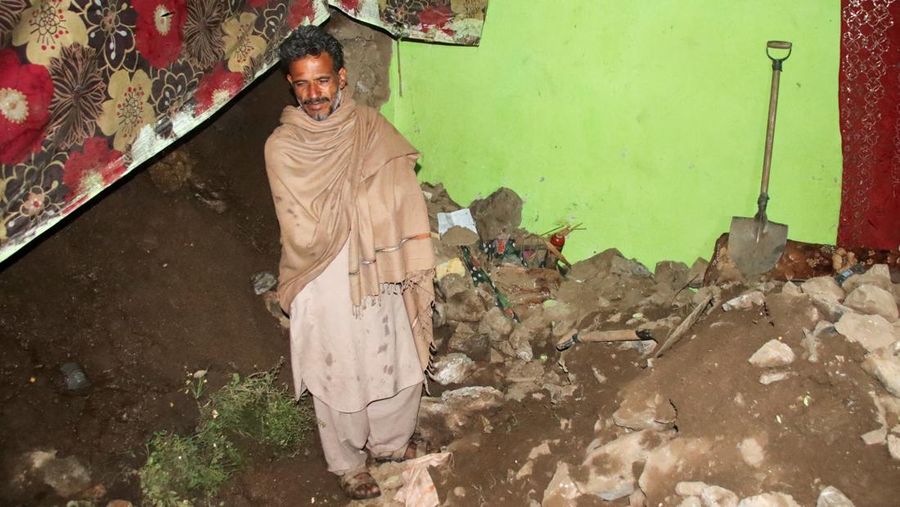 Seseorang berjalan melewati atap sebuah rumah yang runtuh setelah hujan lebat di Abbottabad, provinsi Khyber Pakhtunkhwa di Pakistan, 30 Maret 2026. (REUTERS/Sultan Dogar)