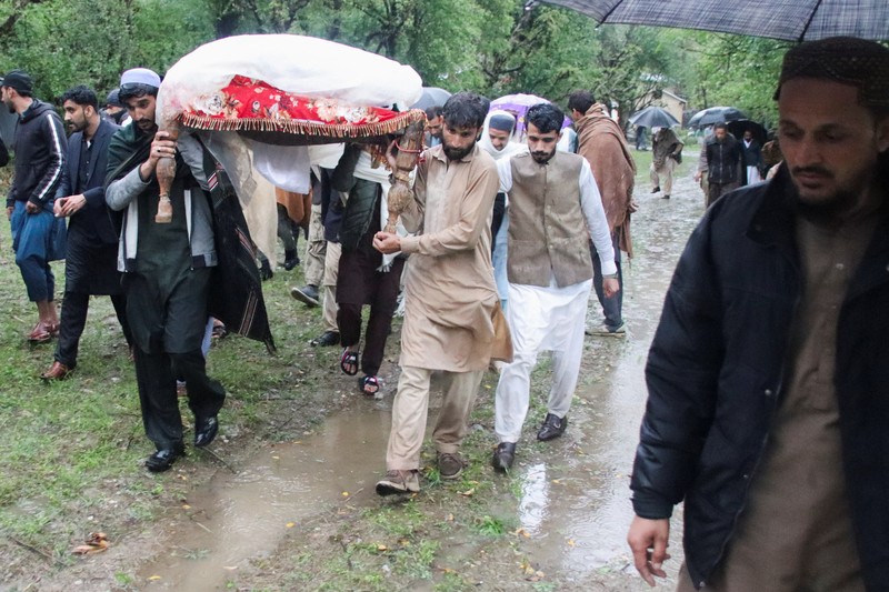 Seseorang berjalan melewati atap sebuah rumah yang runtuh setelah hujan lebat di Abbottabad, provinsi Khyber Pakhtunkhwa di Pakistan, 30 Maret 2026. (REUTERS/Sultan Dogar)