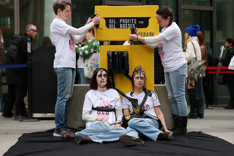 Para demonstran memegang papan tanda selama protes Fossil Free London (London Bebas Bahan Bakar Fosil) terkait ketergantungan pada minyak, di tengah kenaikan harga minyak, seiring berlanjutnya konflik AS-Israel dengan Iran, di luar Kedutaan Besar AS di London, Inggris, 1 April 2026. (REUTERS/Hannah McKay)