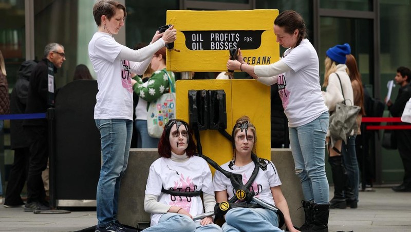 Para demonstran memegang papan tanda selama protes Fossil Free London (London Bebas Bahan Bakar Fosil) terkait ketergantungan pada minyak, di tengah kenaikan harga minyak, seiring berlanjutnya konflik AS-Israel dengan Iran, di luar Kedutaan Besar AS di London, Inggris, 1 April 2026. (REUTERS/Hannah McKay)