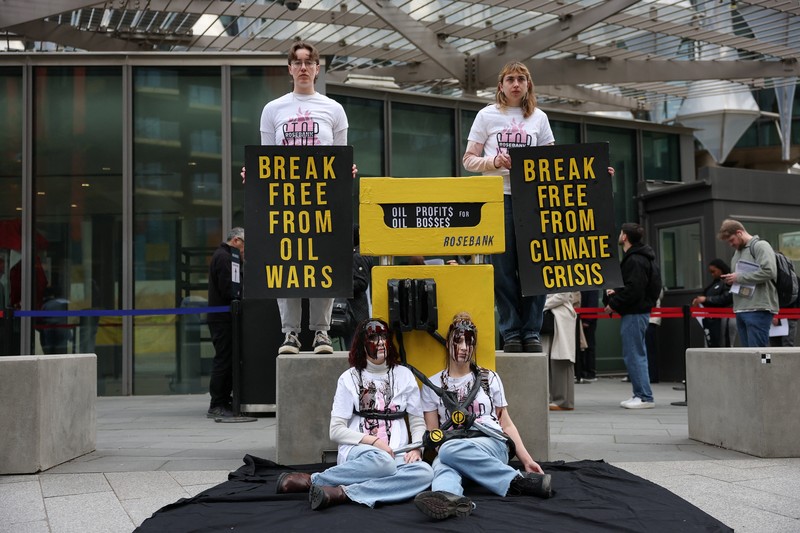 Para demonstran memegang papan tanda selama protes Fossil Free London (London Bebas Bahan Bakar Fosil) terkait ketergantungan pada minyak, di tengah kenaikan harga minyak, seiring berlanjutnya konflik AS-Israel dengan Iran, di luar Kedutaan Besar AS di London, Inggris, 1 April 2026. (REUTERS/Hannah McKay)