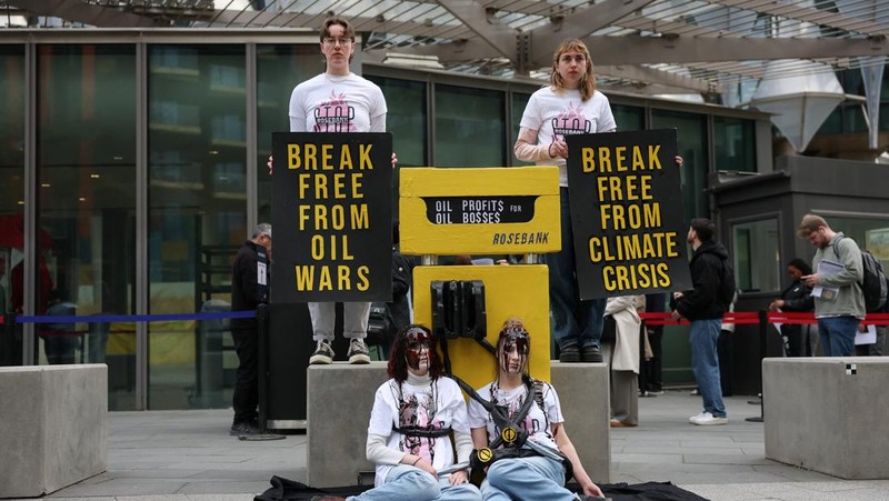 Para demonstran memegang papan tanda selama protes Fossil Free London (London Bebas Bahan Bakar Fosil) terkait ketergantungan pada minyak, di tengah kenaikan harga minyak, seiring berlanjutnya konflik AS-Israel dengan Iran, di luar Kedutaan Besar AS di London, Inggris, 1 April 2026. (REUTERS/Hannah McKay)