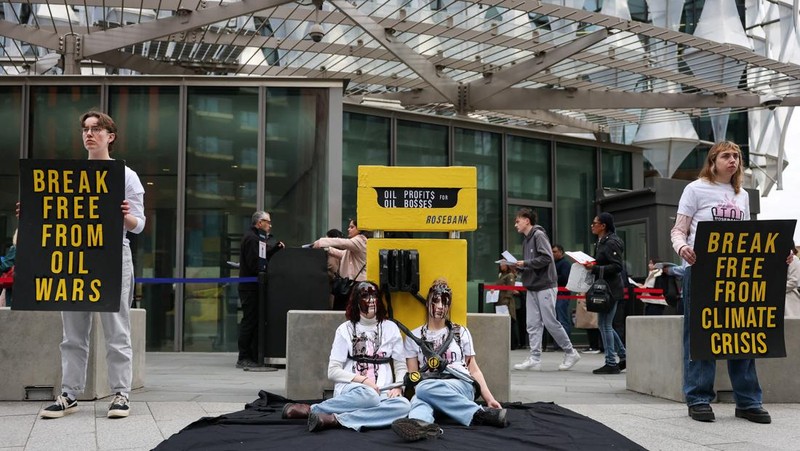Para demonstran memegang papan tanda selama protes Fossil Free London (London Bebas Bahan Bakar Fosil) terkait ketergantungan pada minyak, di tengah kenaikan harga minyak, seiring berlanjutnya konflik AS-Israel dengan Iran, di luar Kedutaan Besar AS di London, Inggris, 1 April 2026. (REUTERS/Hannah McKay)
