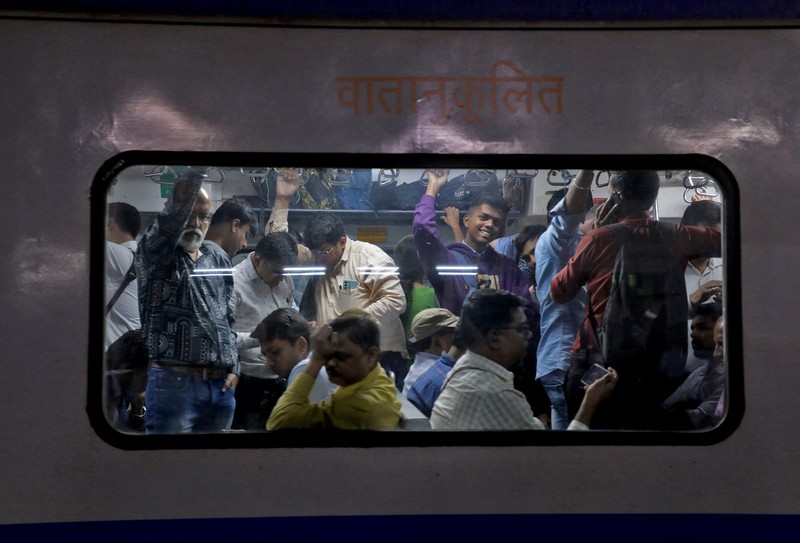 Para penumpang berjalan di atas peron setelah turun dari kereta komuter di stasiun kereta api di Mumbai, India, 21 Januari 2023. (REUTERS/Niharika Kulkarni/File Foto)