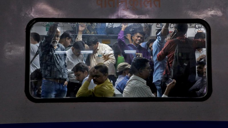 Para penumpang berjalan di atas peron setelah turun dari kereta komuter di stasiun kereta api di Mumbai, India, 21 Januari 2023. (REUTERS/Niharika Kulkarni/File Foto)