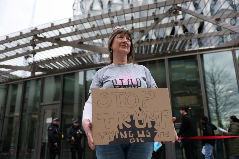 Para demonstran memegang papan tanda selama protes Fossil Free London (London Bebas Bahan Bakar Fosil) terkait ketergantungan pada minyak, di tengah kenaikan harga minyak, seiring berlanjutnya konflik AS-Israel dengan Iran, di luar Kedutaan Besar AS di London, Inggris, 1 April 2026. (REUTERS/Hannah McKay)