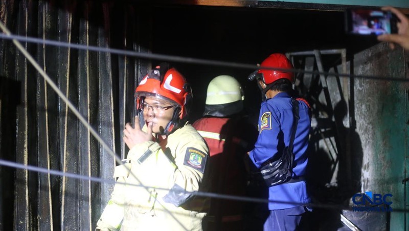 Petugas pemadam kebakaran berusaha memadamkan api pada bangunan yang terdampak setelah Stasiun Pengisian Bulk Elpiji (SPBE) di Cimuning, Mustika Jaya, Bekasi, mengalami kebakaran hebat pada Rabu (1/4/2026) malam. (CNBC Indonesia/Tias Budiarto)
