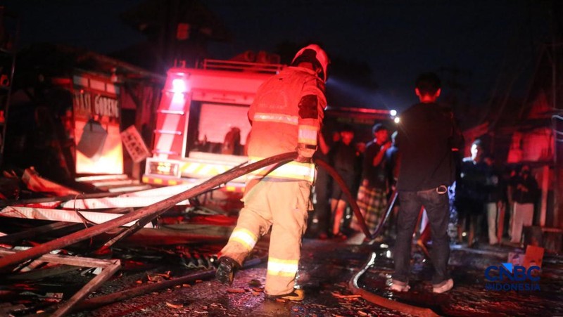 Petugas pemadam kebakaran berusaha memadamkan api pada bangunan yang terdampak setelah Stasiun Pengisian Bulk Elpiji (SPBE) di Cimuning, Mustika Jaya, Bekasi, mengalami kebakaran hebat pada Rabu (1/4/2026) malam. (CNBC Indonesia/Tias Budiarto)