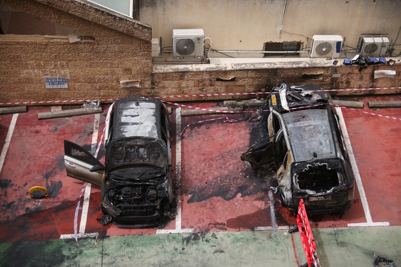 Personel darurat Israel bekerja di samping kendaraan yang hancur di lokasi dampak proyektil, di tengah meningkatnya permusuhan antara Israel dan Hizbullah, sementara konflik AS-Israel dengan Iran terus berlanjut, di Kiryat Ata, Israel utara, 3 April 2026. (REUTERS/Shir Torem)