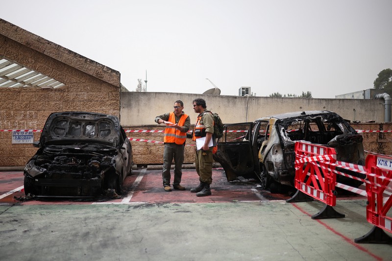 Personel darurat Israel bekerja di samping kendaraan yang hancur di lokasi dampak proyektil, di tengah meningkatnya permusuhan antara Israel dan Hizbullah, sementara konflik AS-Israel dengan Iran terus berlanjut, di Kiryat Ata, Israel utara, 3 April 2026. (REUTERS/Shir Torem)