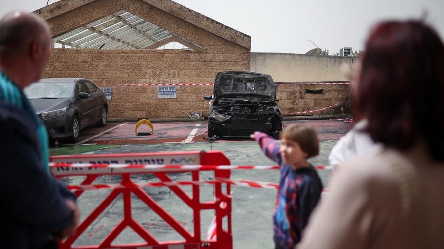 Personel darurat Israel bekerja di samping kendaraan yang hancur di lokasi dampak proyektil, di tengah meningkatnya permusuhan antara Israel dan Hizbullah, sementara konflik AS-Israel dengan Iran terus berlanjut, di Kiryat Ata, Israel utara, 3 April 2026. (REUTERS/Shir Torem)