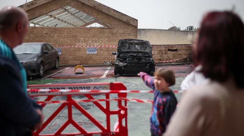 Personel darurat Israel bekerja di samping kendaraan yang hancur di lokasi dampak proyektil, di tengah meningkatnya permusuhan antara Israel dan Hizbullah, sementara konflik AS-Israel dengan Iran terus berlanjut, di Kiryat Ata, Israel utara, 3 April 2026. (REUTERS/Shir Torem)