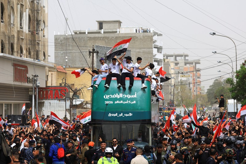 Warga Irak berkumpul untuk merayakan kedatangan tim sepak bola nasional dengan bus terbuka dalam sebuah resepsi publik setelah lolos ke Piala Dunia FIFA untuk pertama kalinya sejak 1986, di Baghdad, Irak, Sabtu (4/4/2026). (REUTERS/Thaier Al-Sudani)