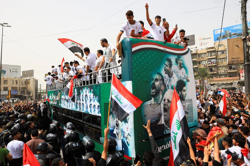 Warga Irak berkumpul untuk merayakan kedatangan tim sepak bola nasional dengan bus terbuka dalam sebuah resepsi publik setelah lolos ke Piala Dunia FIFA untuk pertama kalinya sejak 1986, di Baghdad, Irak, Sabtu (4/4/2026). (REUTERS/Thaier Al-Sudani)