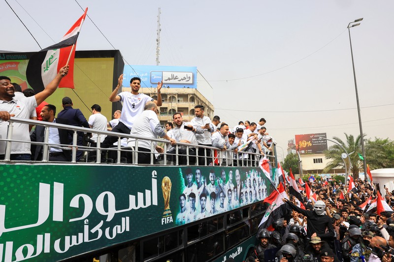 Warga Irak berkumpul untuk merayakan kedatangan tim sepak bola nasional dengan bus terbuka dalam sebuah resepsi publik setelah lolos ke Piala Dunia FIFA untuk pertama kalinya sejak 1986, di Baghdad, Irak, Sabtu (4/4/2026). (REUTERS/Thaier Al-Sudani)