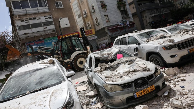 Gambar dari drone yang memperlihatkan personel darurat di lokasi terdampak di lingkungan perumahan, setelah dihujani rudal yang diluncurkan dari Iran, di tengah konflik AS-Israel dengan Iran, di Israel tengah, 6 April 2026. (REUTERS/Roei Kastro)