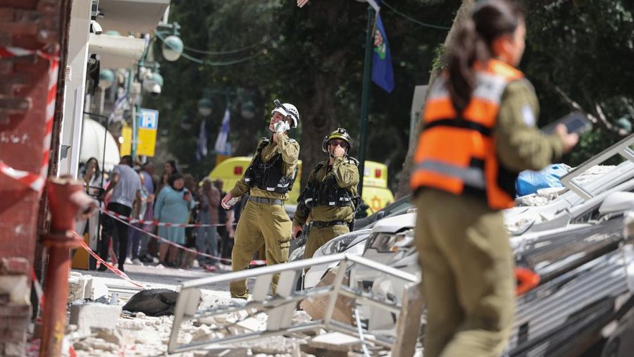 Gambar dari drone yang memperlihatkan personel darurat di lokasi terdampak di lingkungan perumahan, setelah dihujani rudal yang diluncurkan dari Iran, di tengah konflik AS-Israel dengan Iran, di Israel tengah, 6 April 2026. (REUTERS/Roei Kastro)