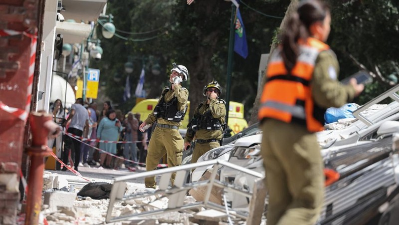 Gambar dari drone yang memperlihatkan personel darurat di lokasi terdampak di lingkungan perumahan, setelah dihujani rudal yang diluncurkan dari Iran, di tengah konflik AS-Israel dengan Iran, di Israel tengah, 6 April 2026. (REUTERS/Roei Kastro)