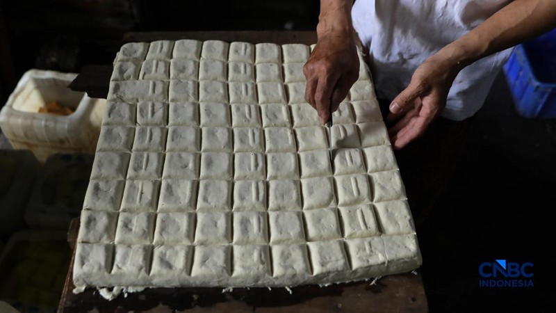 Pekerja membuat tahu berbahan kedelai impor di Kawasan Duren Tiga, Jakarta, Rabu (8/4/2026). (CNBC Indonesia/Muhammad Sabki)