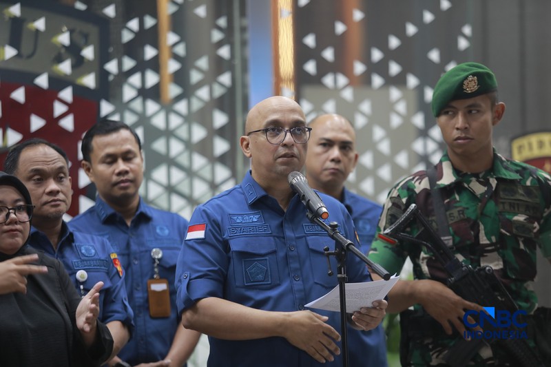 Petugas mendampingi tersangka perkara dugaan pengadaan minyak mentah dan produk kilang Irawan Prakoso (tengah) seusai menjalani pemeriksaan di Kejaksaan Agung, Jakarta, Kamis (9/4/2026). Kejaksaan Agung menetapkan tujuh tersangka dalam kasus dugaan korupsi pengadaan minyak mentah dan produk kilang di Pertamina Energy Trading Limited (Petral) atau Pertamina Energy Services (PES) Pte Ltd. (CNBC Indonesia/Muhammad Sabki)