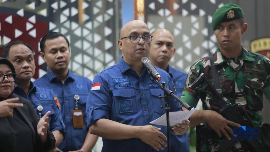 Tersangka kasus korupsi tata kelola minyak mentah berjalan menuju mobil tahanan di gedung Kejaksaan Agung, Jakarta, Kamis (9/4/2026) malam. (CNBC Indonesia/Muhammad Sabki)