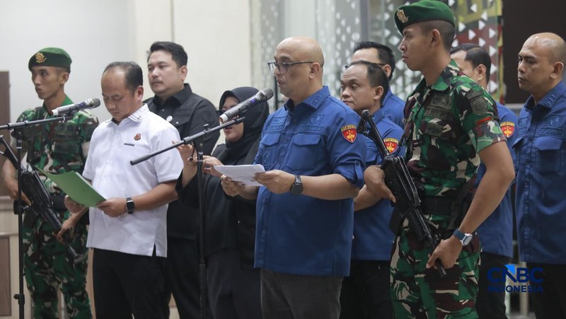 Tersangka kasus korupsi tata kelola minyak mentah berjalan menuju mobil tahanan di gedung Kejaksaan Agung, Jakarta, Kamis (9/4/2026) malam. (CNBC Indonesia/Muhammad Sabki)
