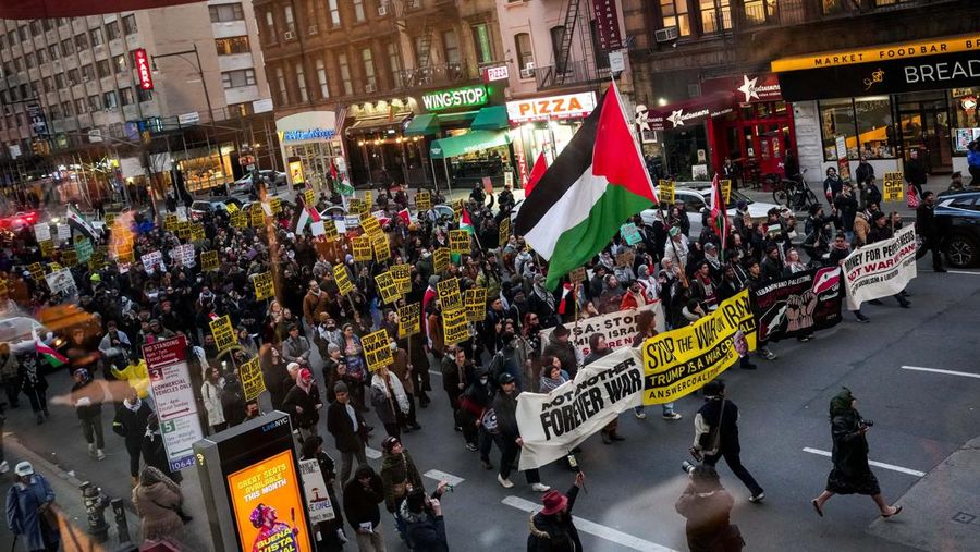 Seorang demonstran membawa potret mendiang Pemimpin Tertinggi Iran Ayatollah Ali Khamenei selama protes menentang aksi militer di Iran dekat Gedung Putih di Washington, D.C., AS, 8 April 2026. (REUTERS/Evelyn Hockstein)