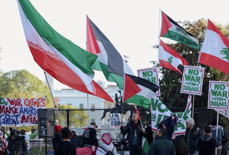 Seorang demonstran membawa potret mendiang Pemimpin Tertinggi Iran Ayatollah Ali Khamenei selama protes menentang aksi militer di Iran dekat Gedung Putih di Washington, D.C., AS, 8 April 2026. (REUTERS/Evelyn Hockstein)