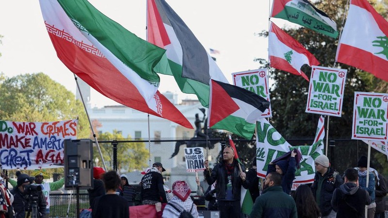 Seorang demonstran membawa potret mendiang Pemimpin Tertinggi Iran Ayatollah Ali Khamenei selama protes menentang aksi militer di Iran dekat Gedung Putih di Washington, D.C., AS, 8 April 2026. (REUTERS/Evelyn Hockstein)